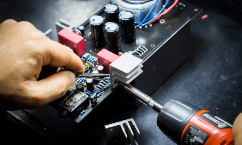 PCB final assembly showing tools being used to fit a heat sink.